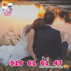 wedding-couple-sitting-on-green-grass-in-front-of-body-of-70737